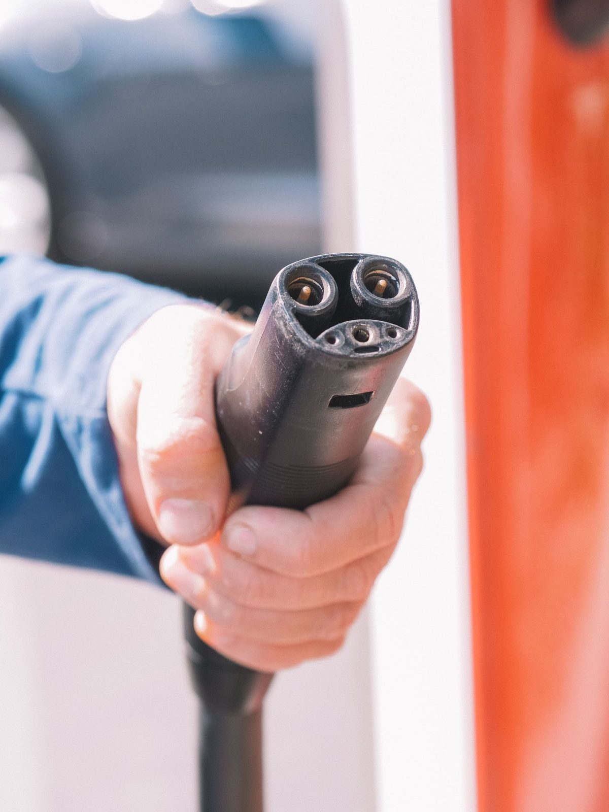 Mão segurando o conector de recarga rápida